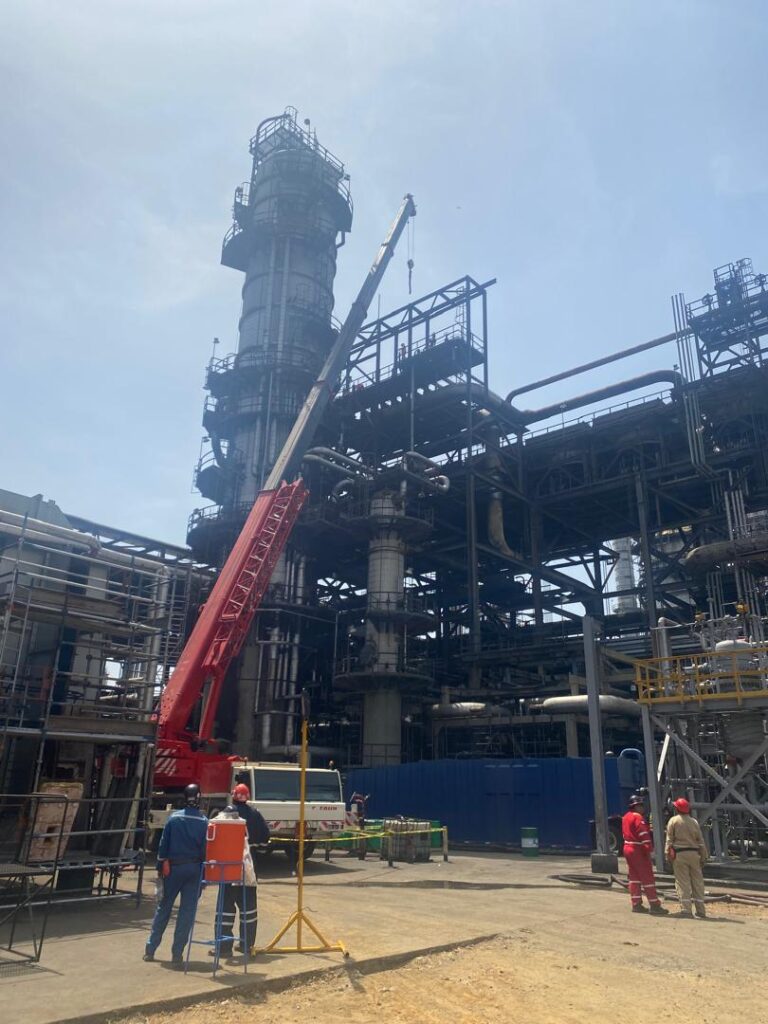 Grúa Special Truck ejecutando izaje crítico entre estructuras en planta industrial de Venezuela